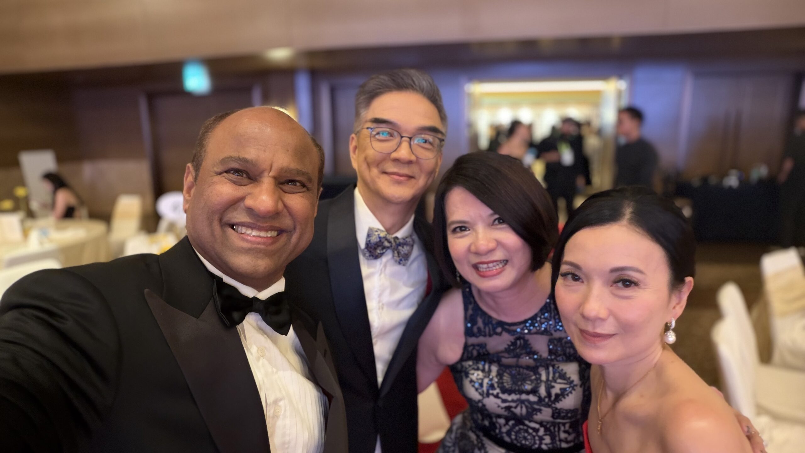 Four attendees posing together for a selfie at the gala.